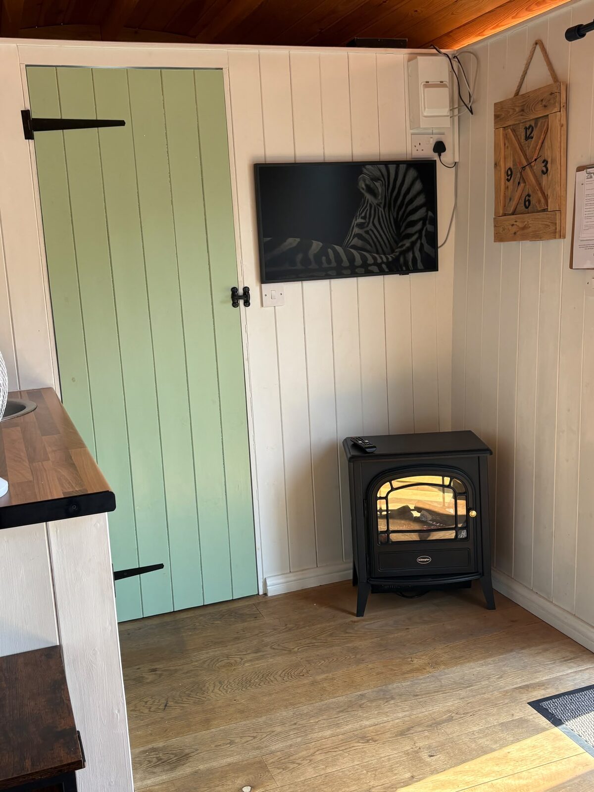 Electric log burner and wall-mounted Smart TV inside the shepherd's hut