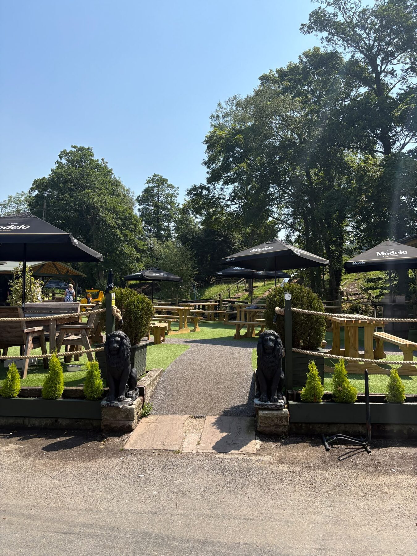 Parasol-shaded tables on the outside terrace at The Little Mill Inn