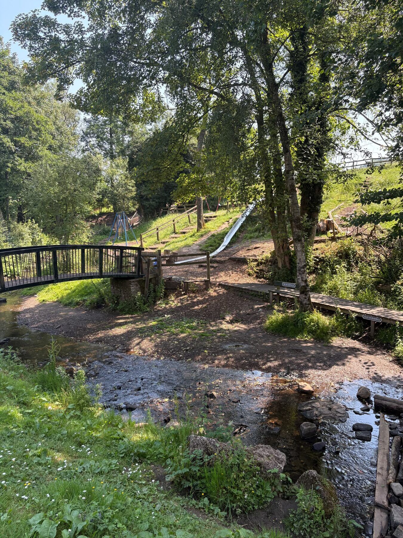The footbridge and shallow brook for paddling below the playground
