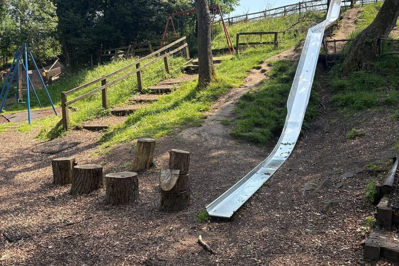 The adventure playground slide and swings in the grounds at The Little Mill Inn