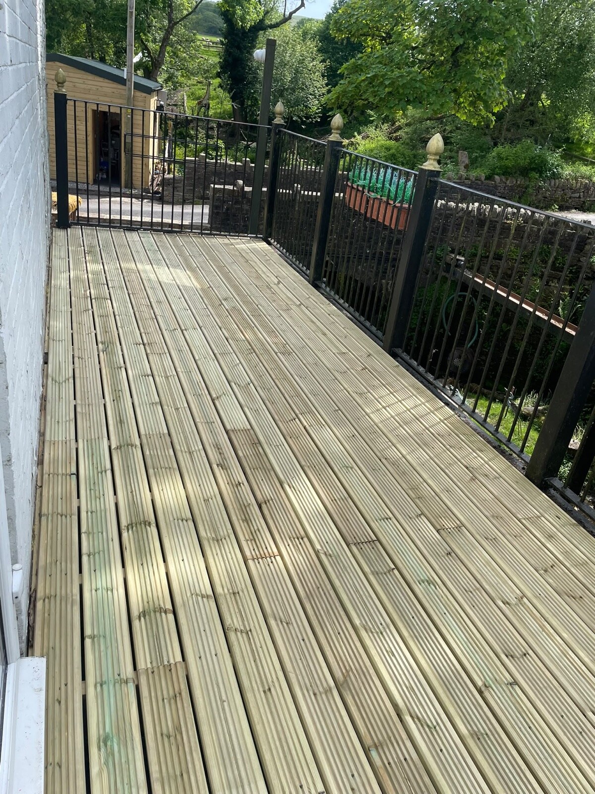 Private timber decking with iron railings overlooking the gardens