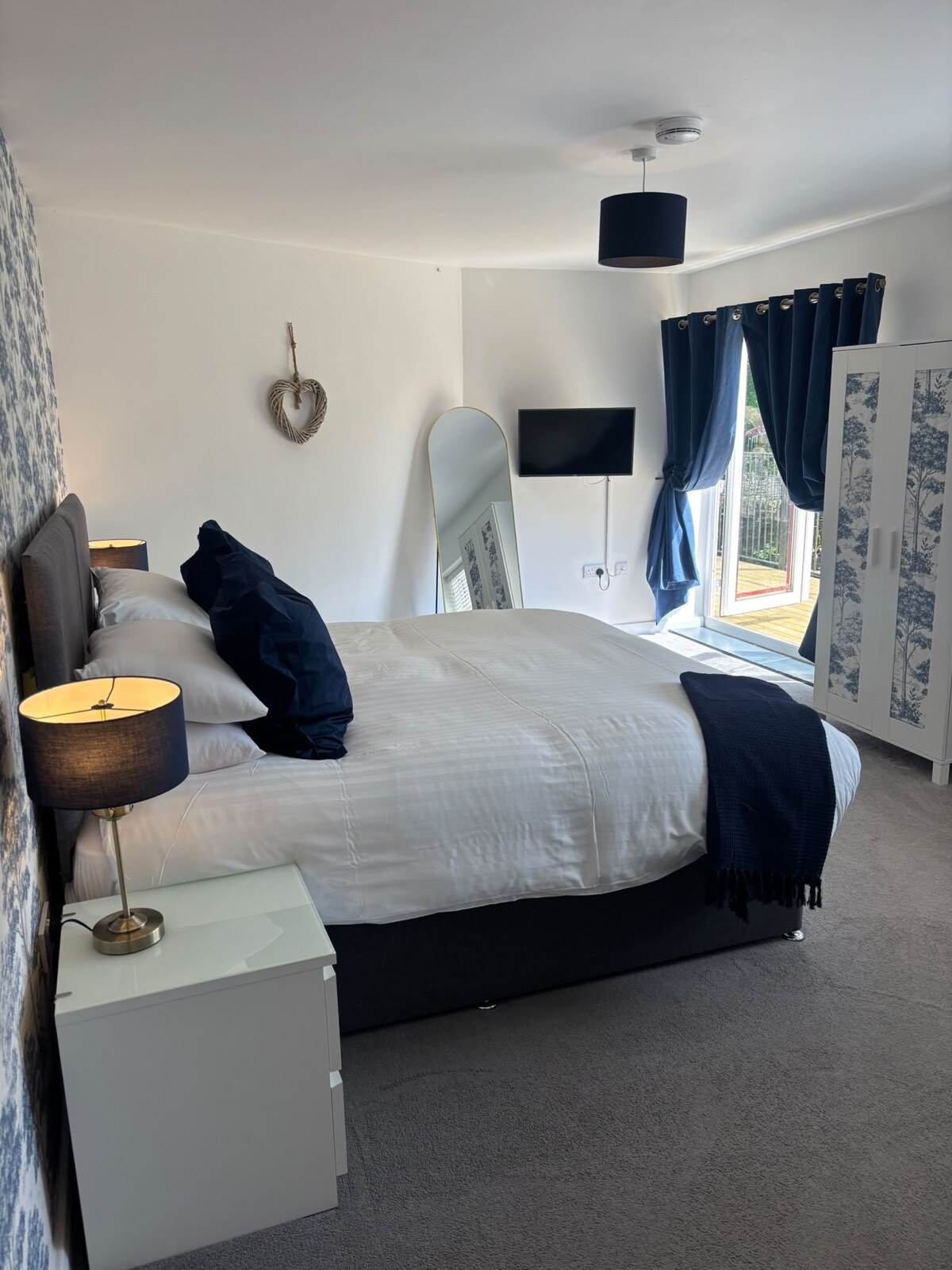 A freshly refurbished double room with balcony doors at The Little Mill Inn